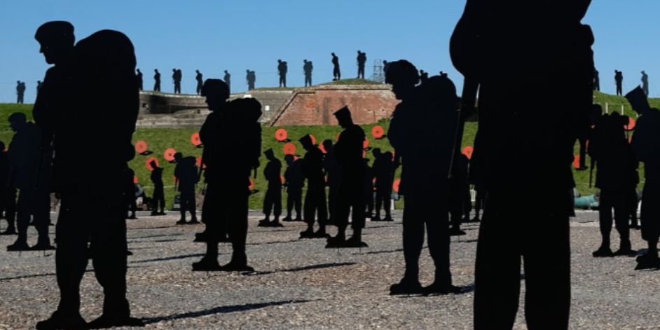 A photo of an outdoor parade ground at Fort Nelson with many metal framed soldier silhouettes that mark the lives lost in the Falkland's conflict.