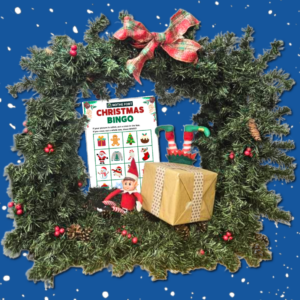 A square image with a blue background with snow falling. In the foreground is a green box-shaped christmas wreath with a red bow on top. In the middle is a Christmas bingo sheet with pictures, an Elf in a red and white costume sitting beside a brown paper-wrapped present. Behind the present a pair of red and green elf legs can be seen.