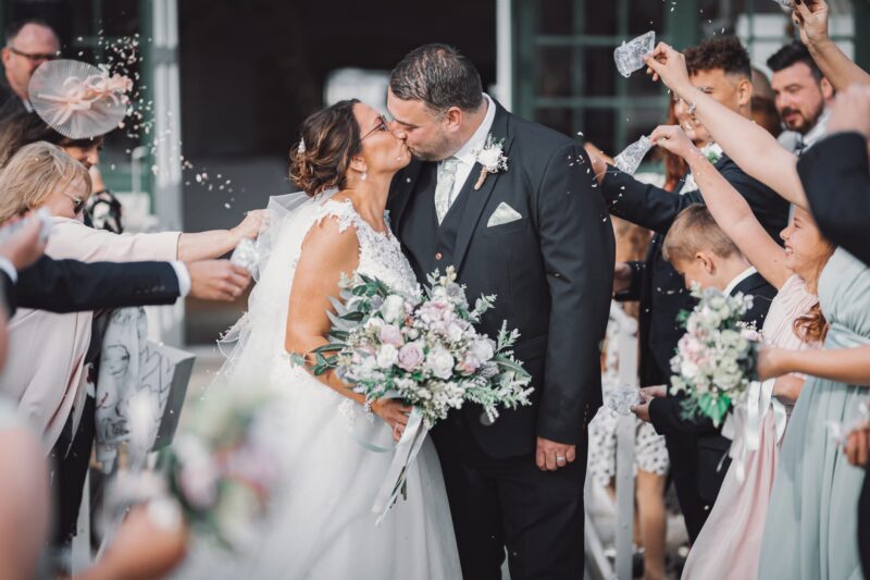A married couple kiss as their ceremony concludes.