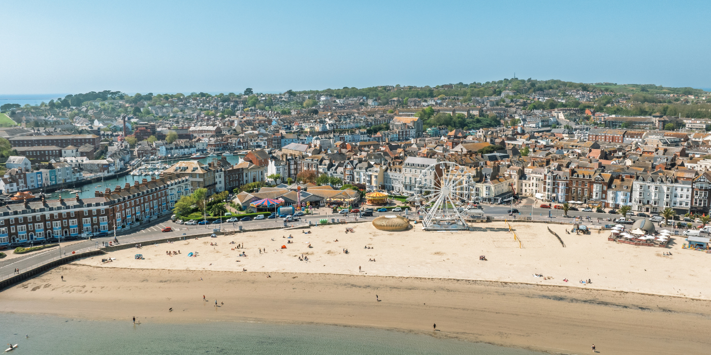 A large landscape drone photo of weymouth beach on a sunny day