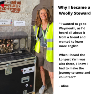 A photo of Aline, a steward in a hi-viz yellow jacket standing beside their favourite knitted scene of a train of soldiers. The text reads ' why i became a woolly steward: "I wanted to go to Weymouth, as I’d heard all about it from a friend and wanted to learn more English. When I heard the Longest Yarn was also there, I knew I had to make the journey to come and volunteer!”